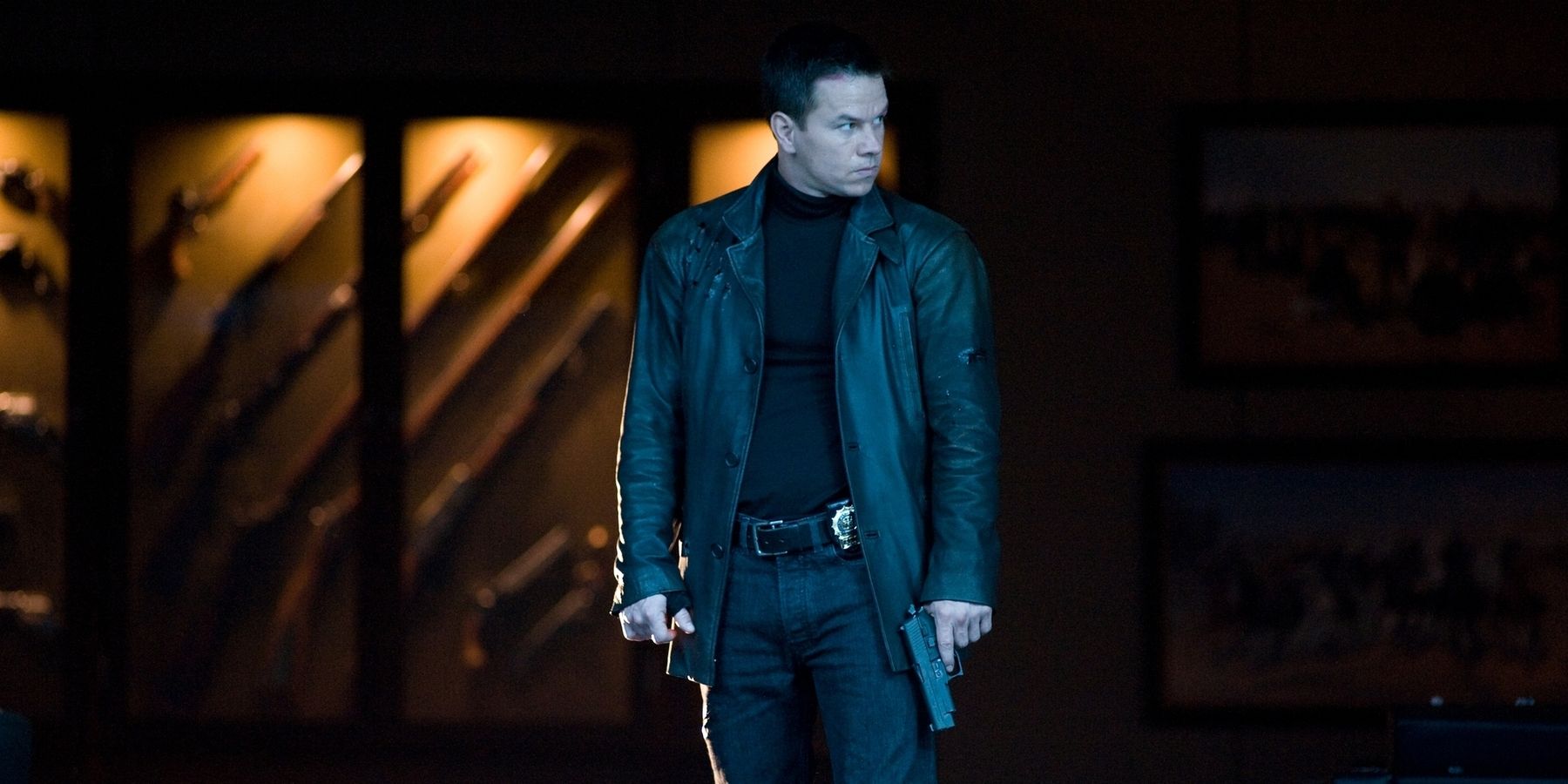 Mark Wahlberg as Max Payne wearing a black coat and holding a pistol in 'Max Payne'