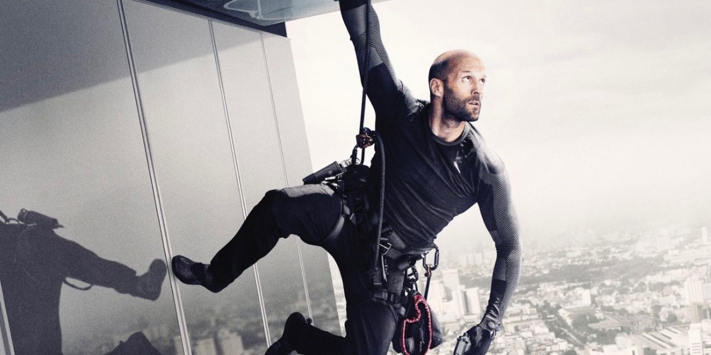 Jason Statham hanging from a building in Mechanic: Resurrection