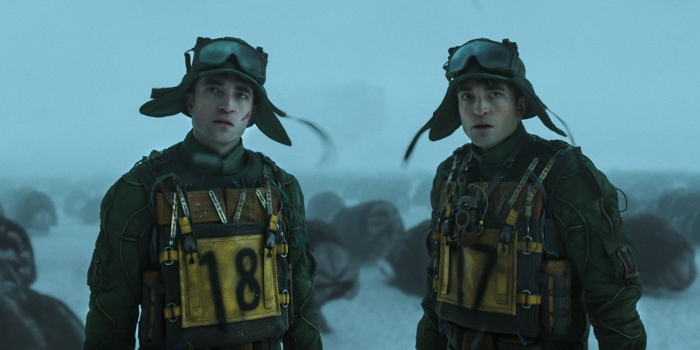 Robert Pattinson as two Mickeys standing in the snow surrounded by aliens in Mickey 17.