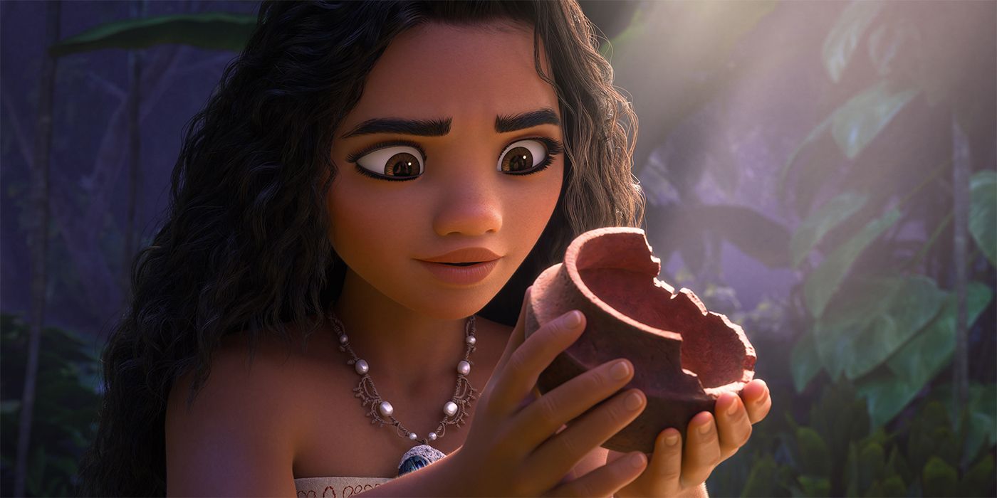 Moana holding up a piece of broken pottery to examine it