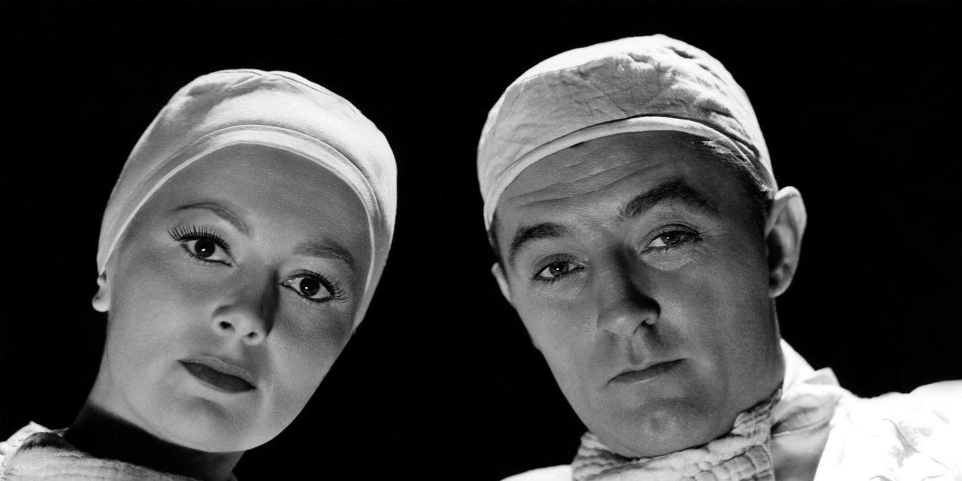 Two doctors look down at the camera wearing medical scrubs in Not as a Stranger.