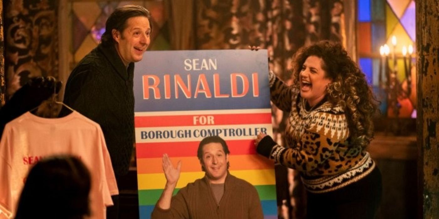 Anthony Atamanuik & Marissa Jaret Winokur stand next to a sign for a pride parade in What We Do in the Shadows.