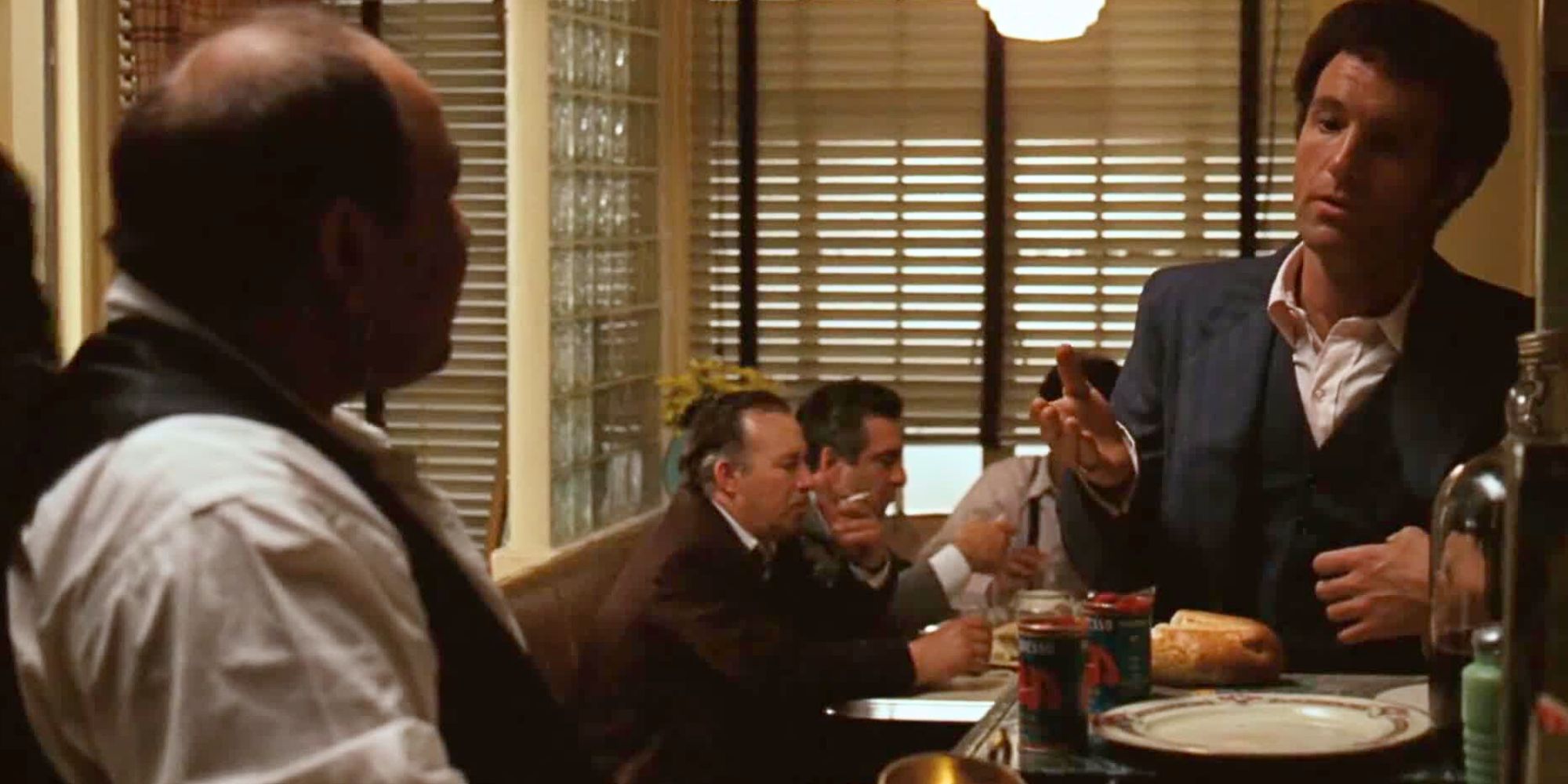 Richard S. Castellano standing in front of a stove looking at James Caan next to him in The Godfather (1972)