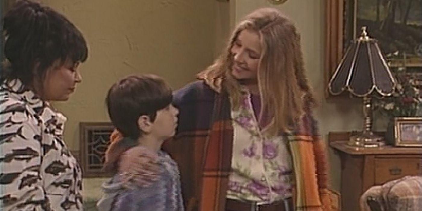 Sarah Chalke as Becky comforting a young DJ with her arm around him as Roseanne looks on in Roseanne
