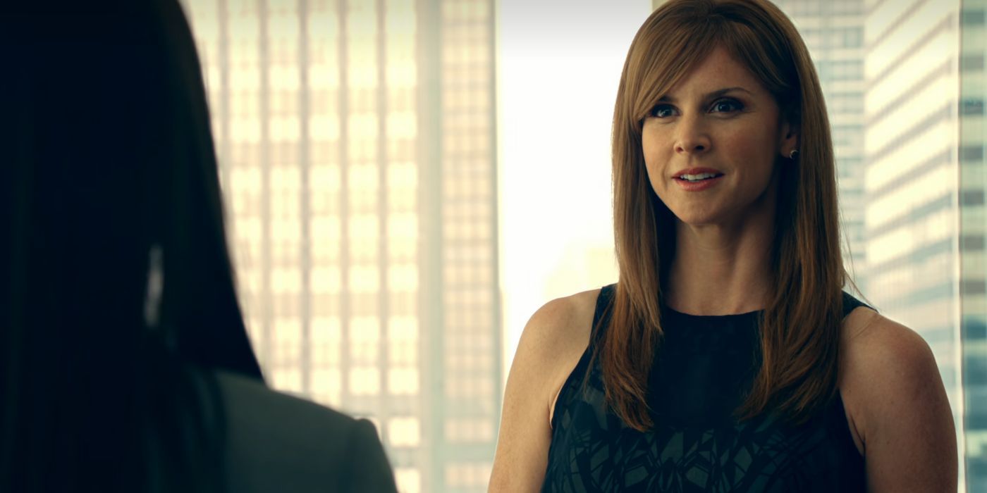 Sara Rafferty as Donna Paulsen standing in an office in Suits