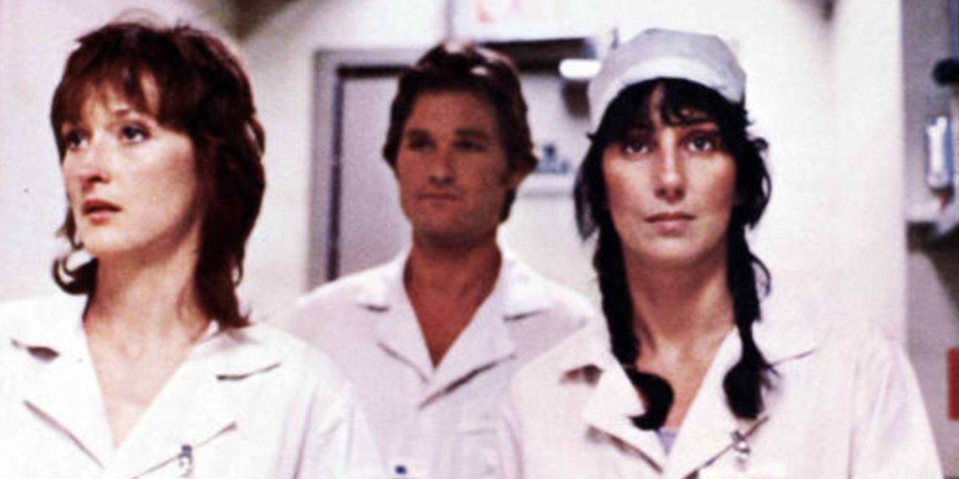 Meryl Streep, Kurt Russell, and Cher as Karen, Drew, and Dolly walking down the plant hallway wearing white uniforms in 'Silkwood'