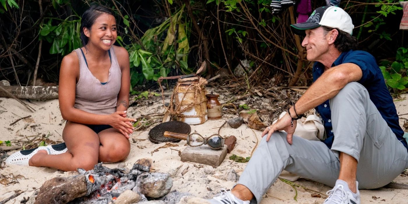 Erika and host Jeff Probst by a small fire as she talks to him about the Hourglass Advantage on Survivor 41.