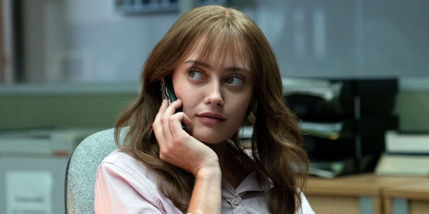 Ella Purnell as Rhiannon sitting in a chair while on the phone in Sweetpea