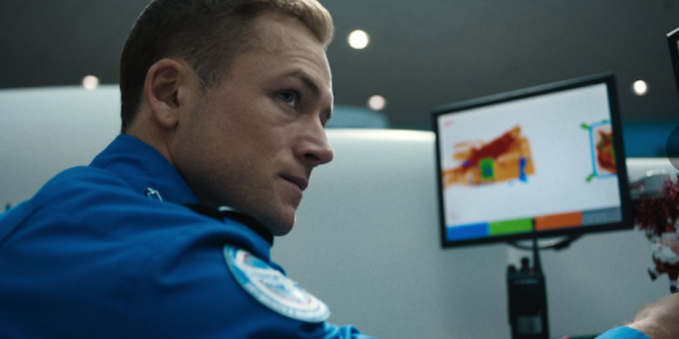 Taron Edgerton looking to the side in front of an airport security monitor in &lsquo;Carry-On&rsquo;.