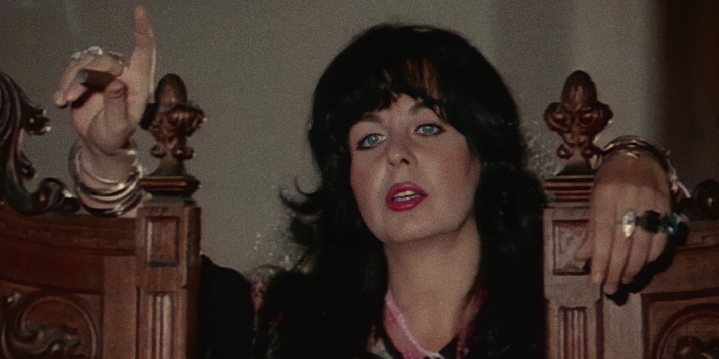 A woman rests her hands on the back of ornate wood chairs in The Angel of Vengeance - The Female Hamlet (1976).