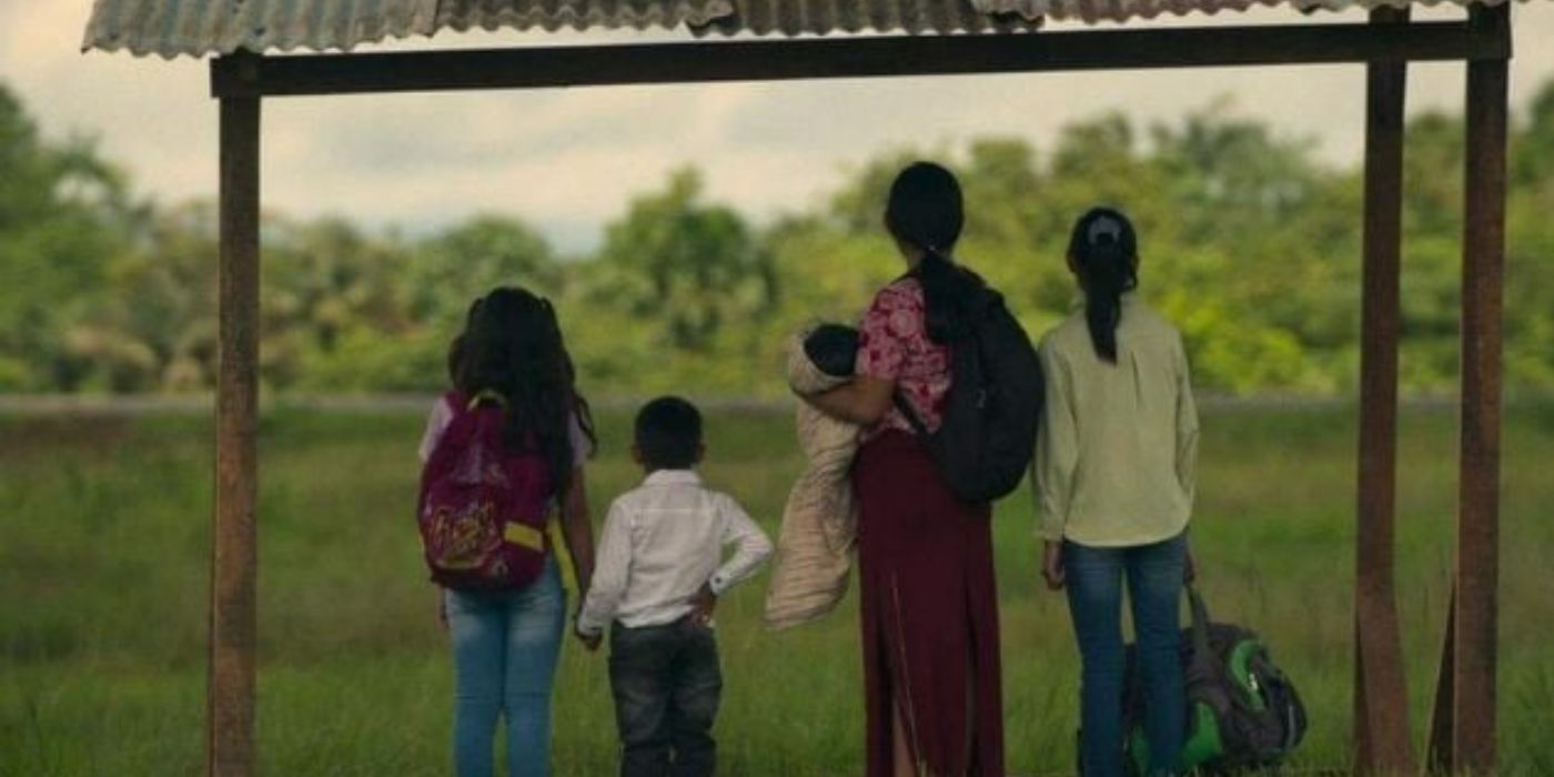 Children facing backward, staring into a lush field