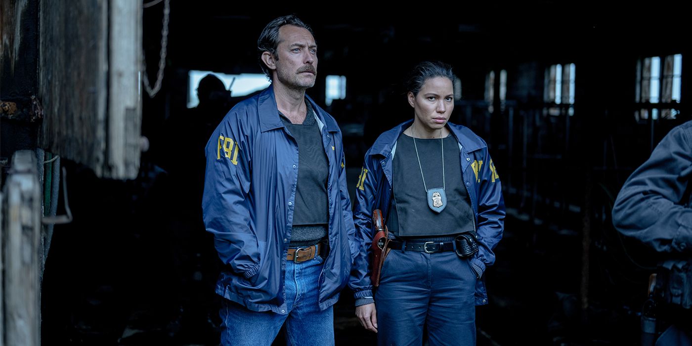 Husk (Jude Law) and Carney (Jurnee Smollett) in their police uniforms with hands in their pockets