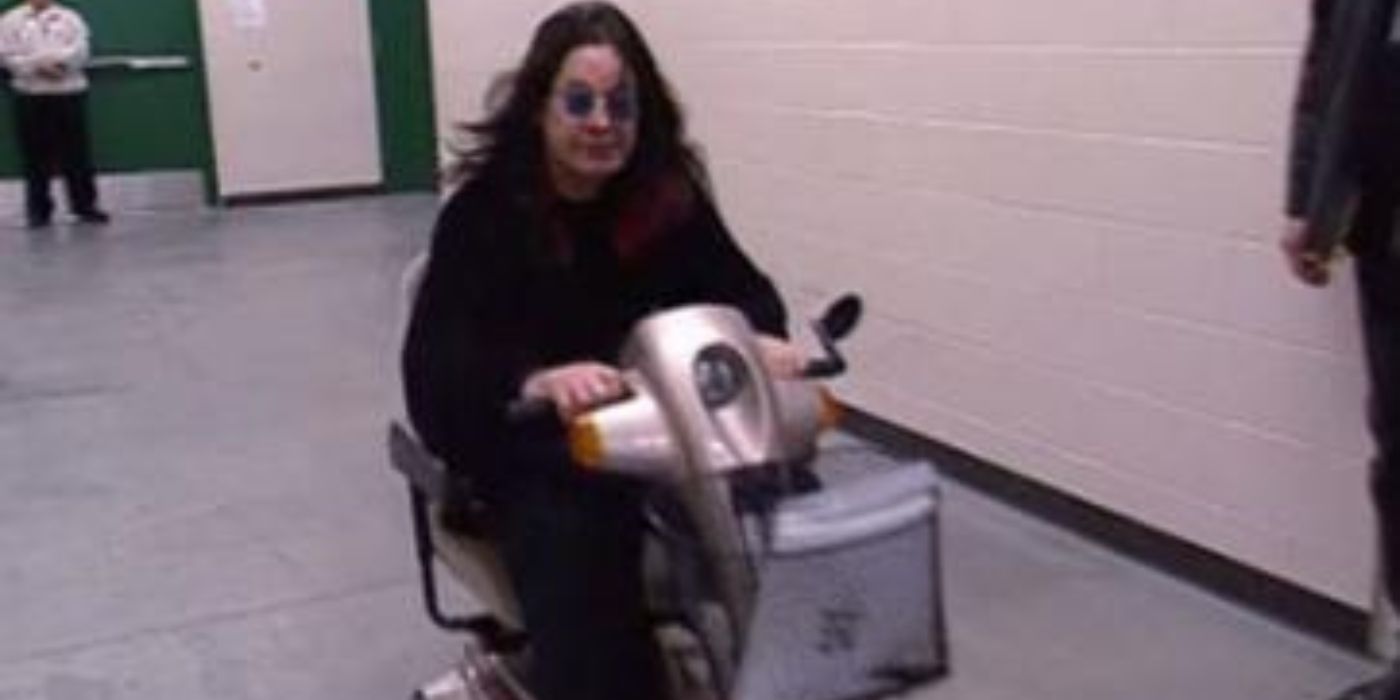 Ozzy Osbourne rides on a scooter down a hallway on The Osbournes.