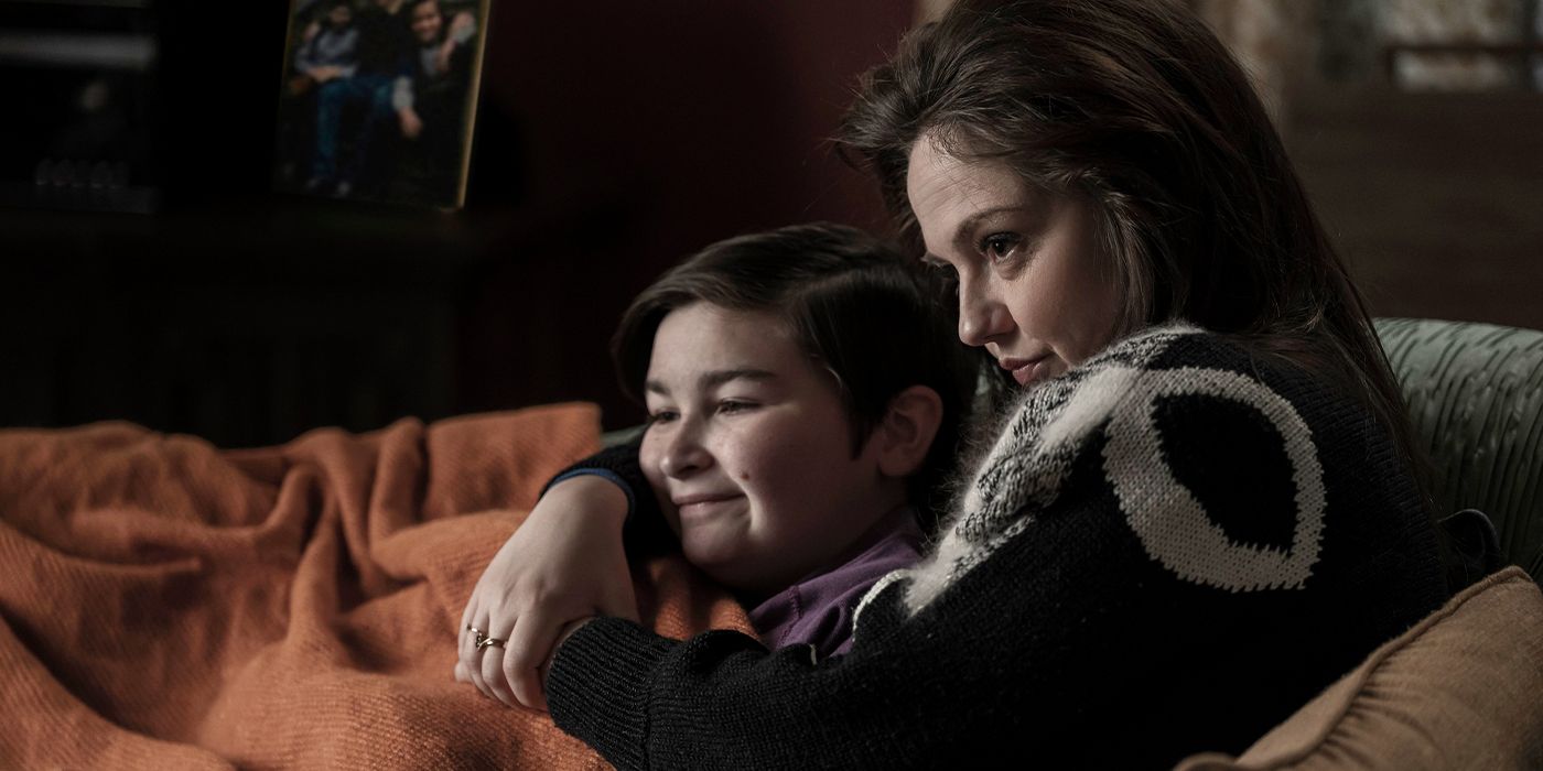 Emily Meade as Francis holding a young Oz Cobb (Ryder Allen) on a couch with blankets