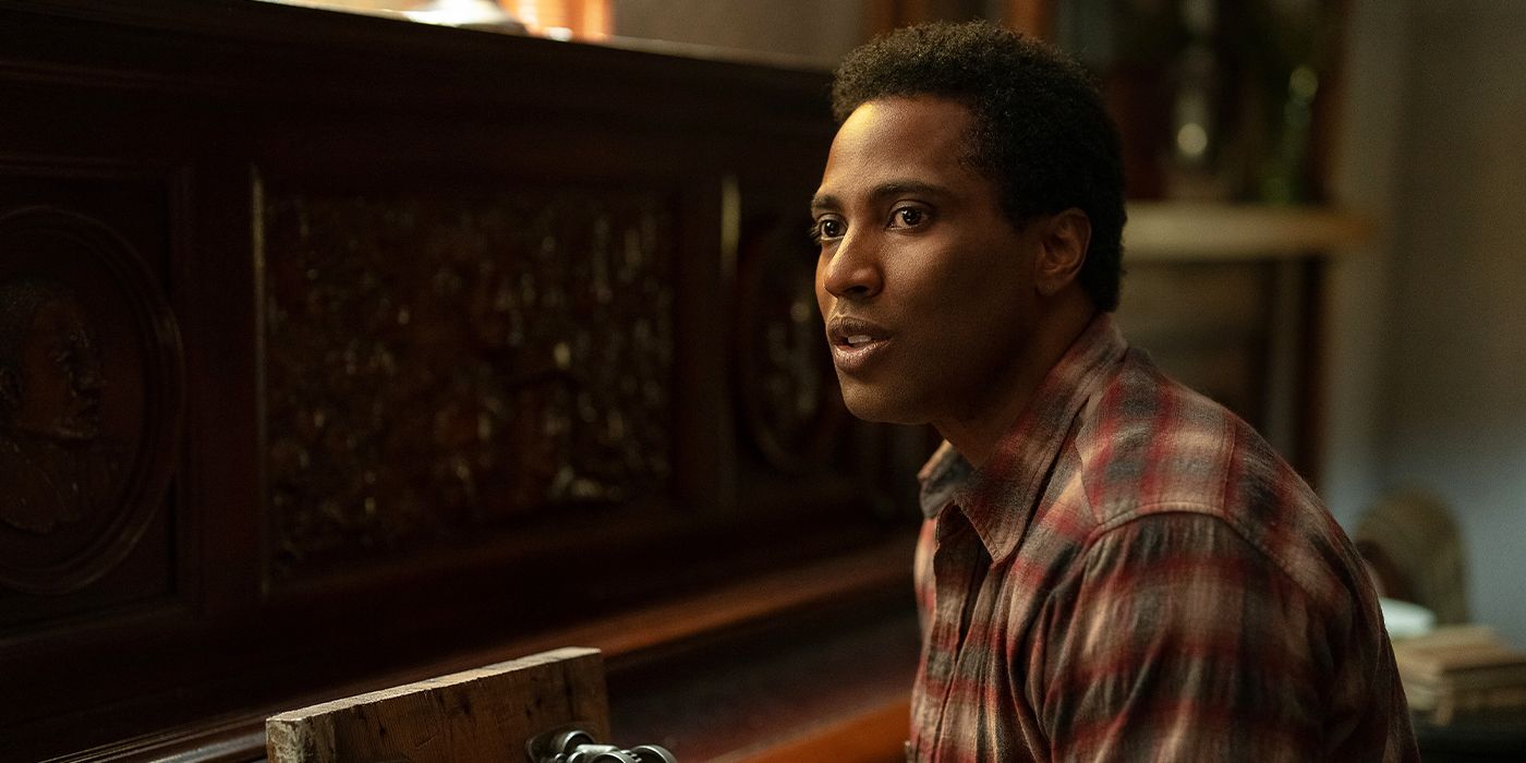 Boy Willie (John David Washington) sitting on a piano bench looking at someone off-camera