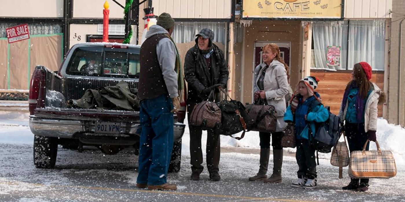The Benson family stranded in town in falling snow holding their luggage in The Town Christmas Forgot.