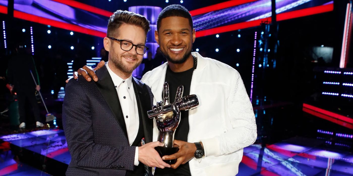 Josh Kaufman holds a trophy and stands next to his coach Usher after he wins Season 6 on The Voice.