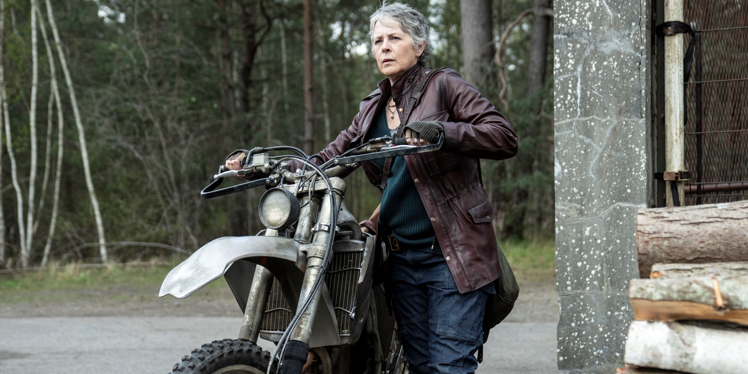 Melissa McBride as Carol walking with her motorcyle in The Walking Dead: Daryl Dixon Season 2