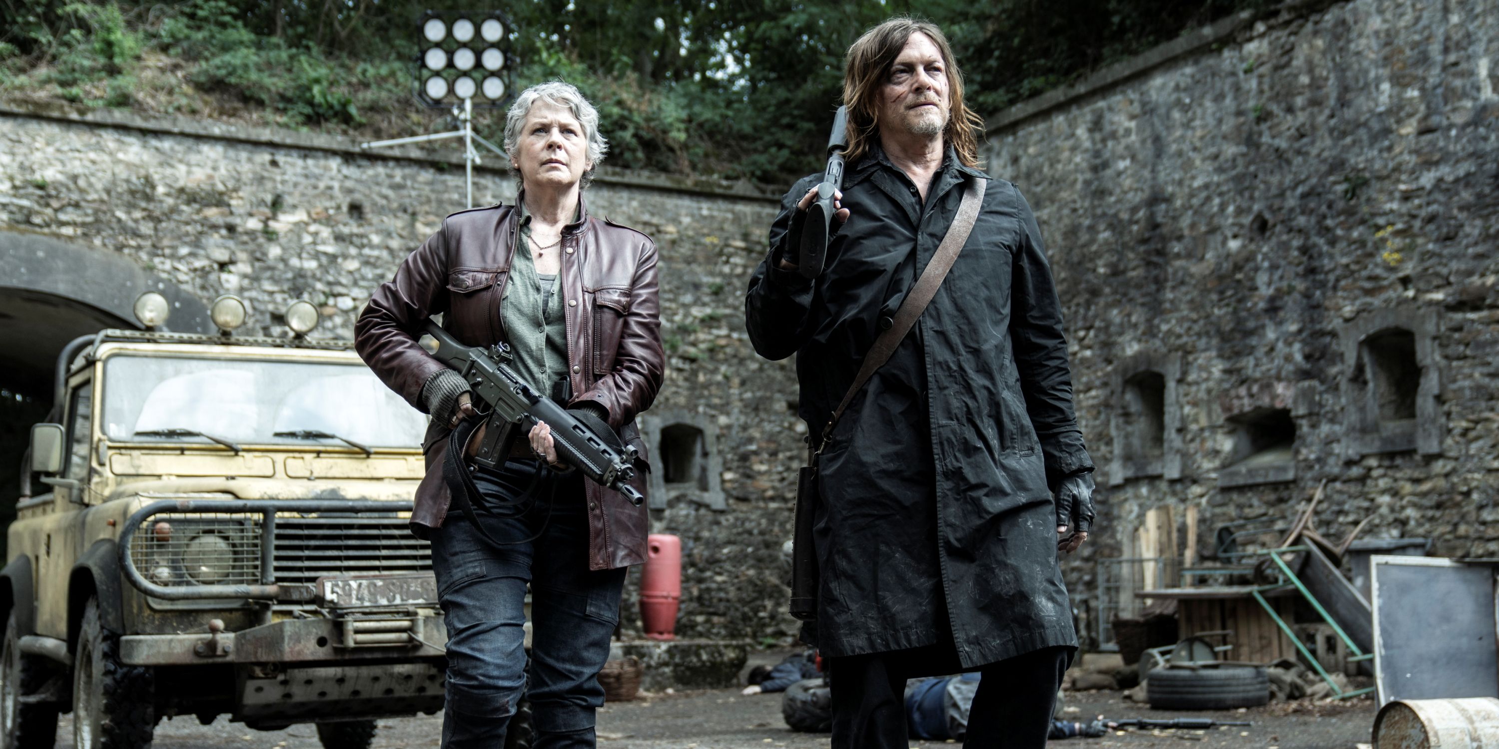 Norman Reedus as Daryl and Melissa McBride as Carol walking with weapons in The Walking Dead: Daryl Dixon