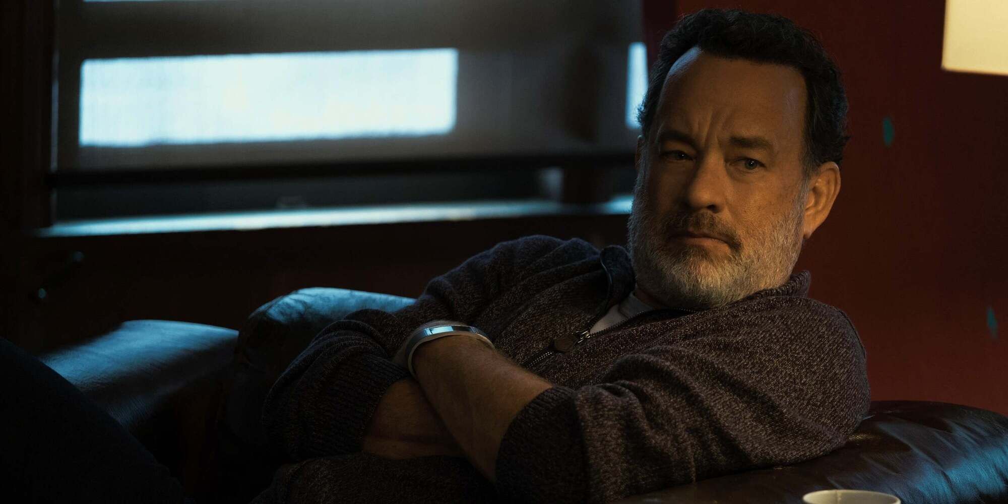 Tom Hanks as Eamon Bailey sitting on a couch in 'The Circle' (2017)