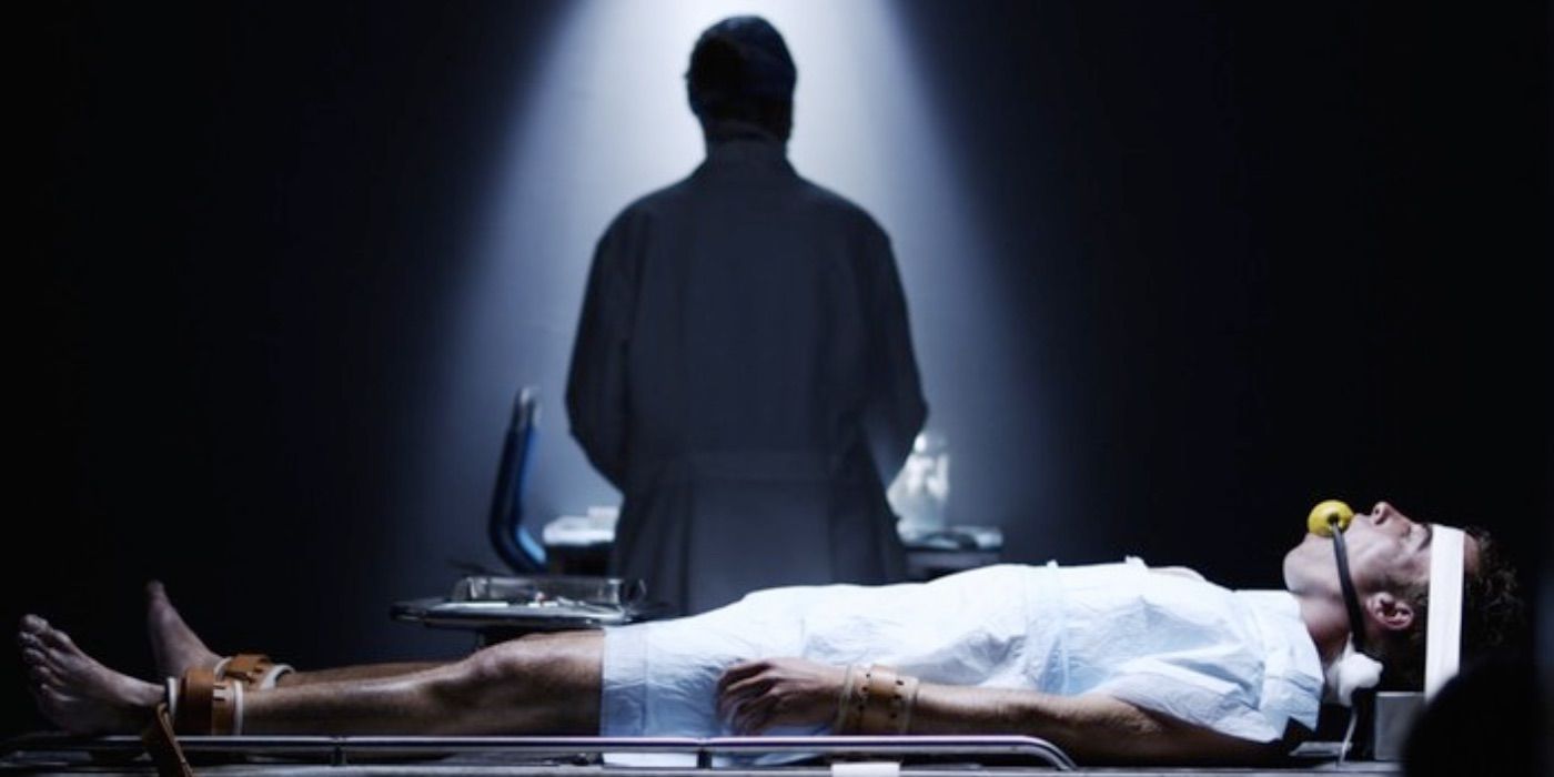 doctor stands over a man who is bound to a table, in Vile (2011)