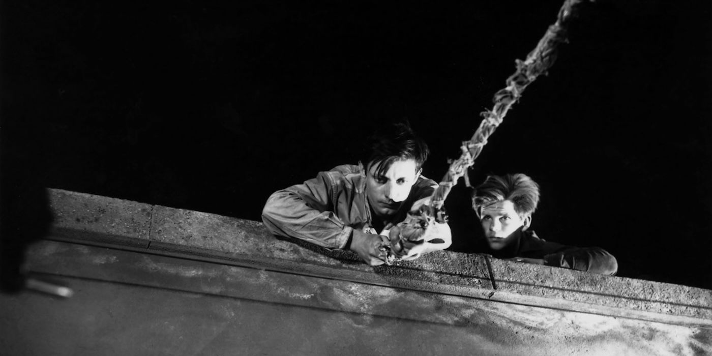 Two men looking down from a roof in A Man Escaped