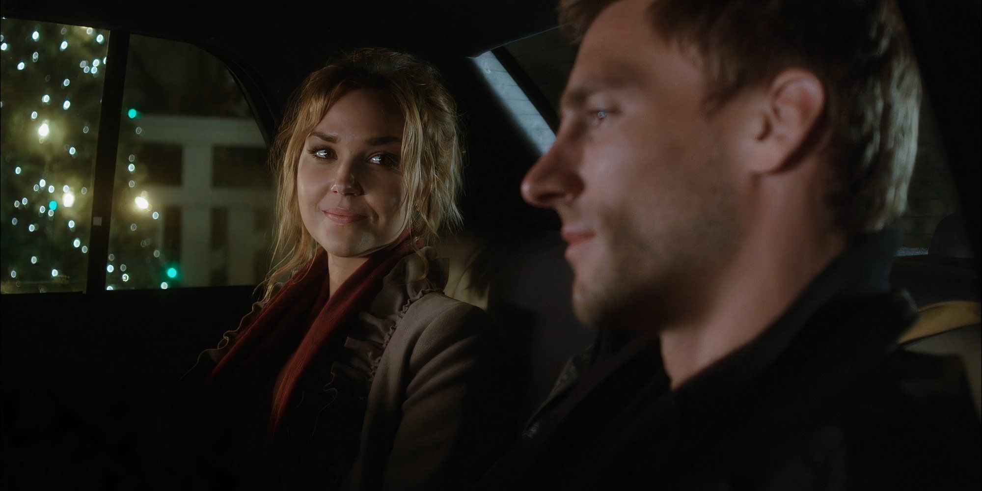Arielle Kebbel as Jessie and Andrew W. Walker as Aiden MacTiernan sit in a car in A Bride for Christmas.