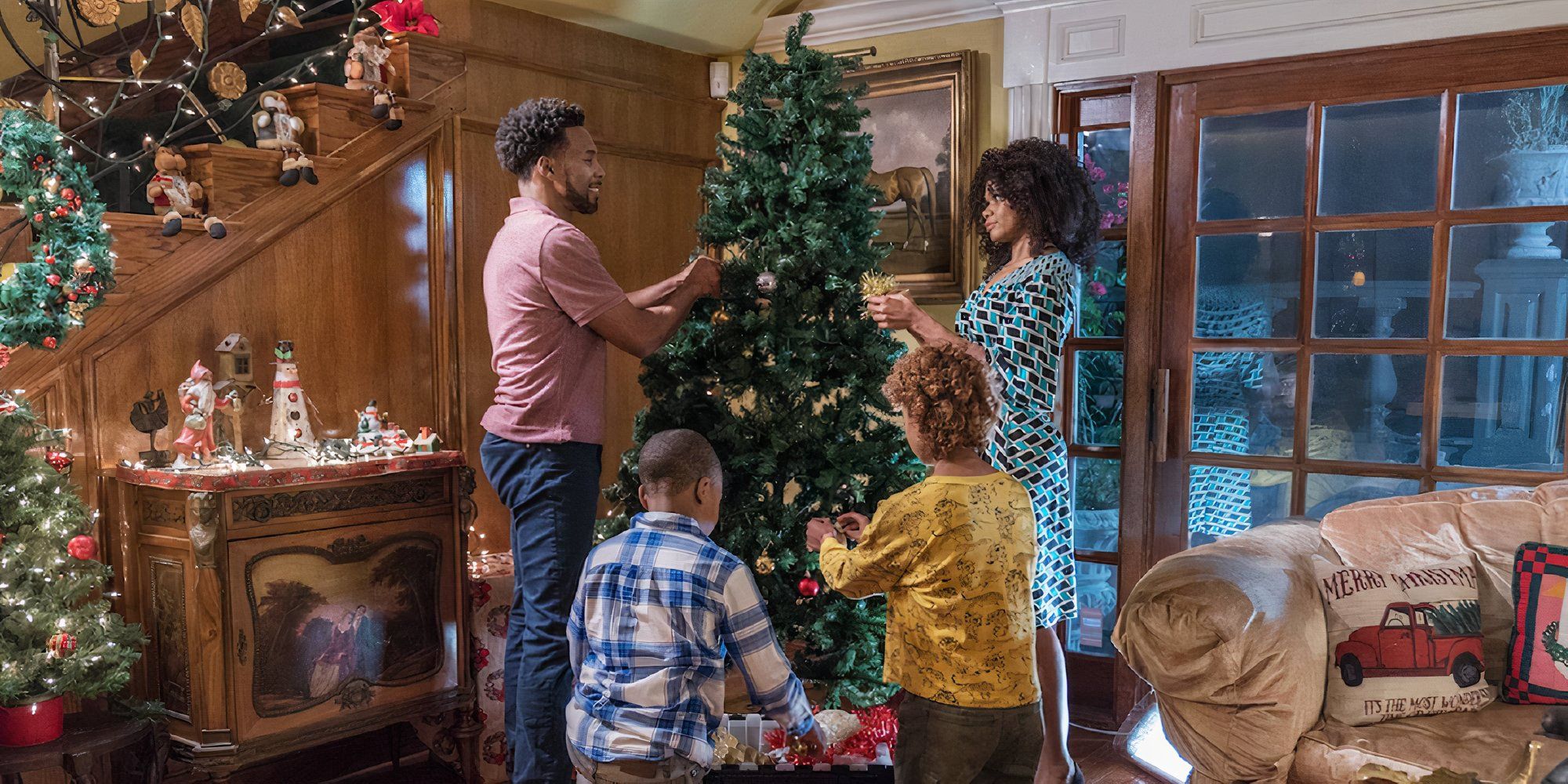 A family decorates a family tree in Carole&rsquo;s Christmas