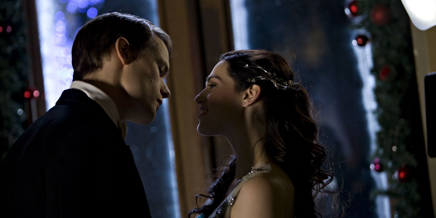 Ashton (Sam Heughan) wearing a tuxedo and leaning in to kiss Jules (Katie McGrath) in Hallmark's A Princess for Christmas