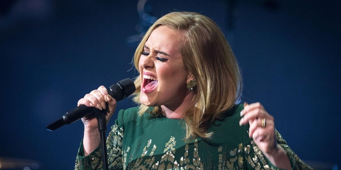 Adele sings into a handheld microphone in Adele: Live in London.