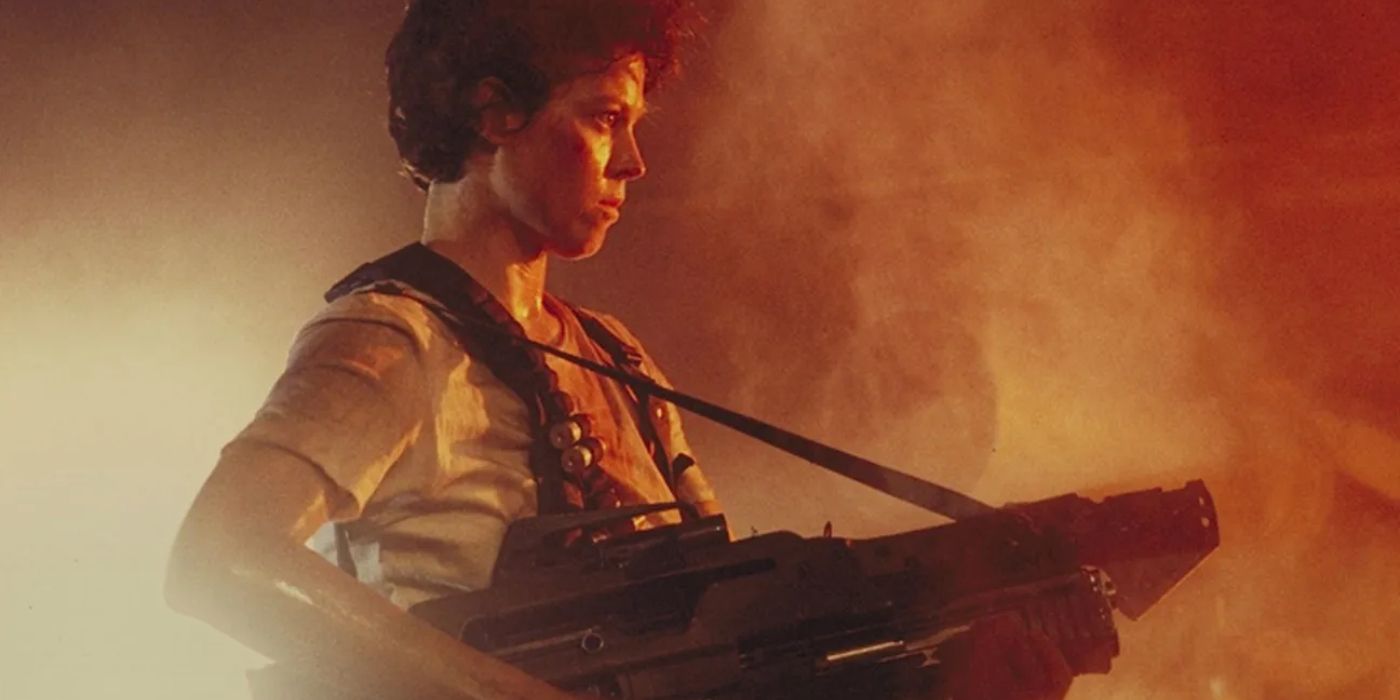 Ellen Ripley (Sigourney Weaver), 'Yabancılar' (1986) 'da dumandan portakal ışığı parlarken bir makineli tüfek tutuyor.