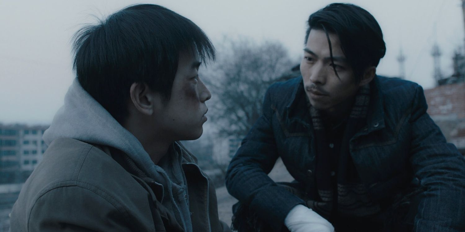 A man talking with a young man with a bruised face in An Elephant Sitting Still - 2018
