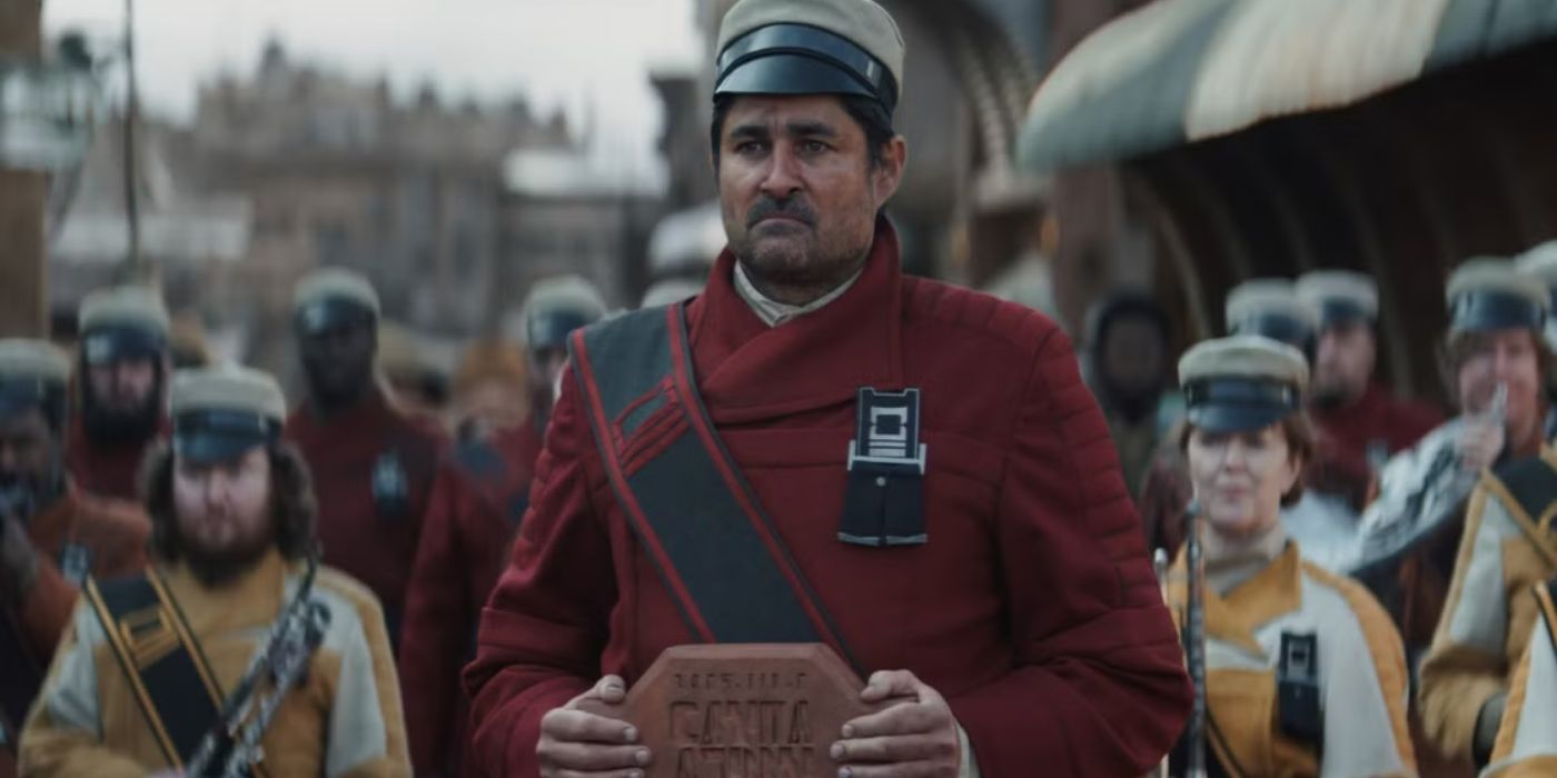 Brasso, who is wearing a red uniform, leads a funeral procession in Star Wars' Andor.
