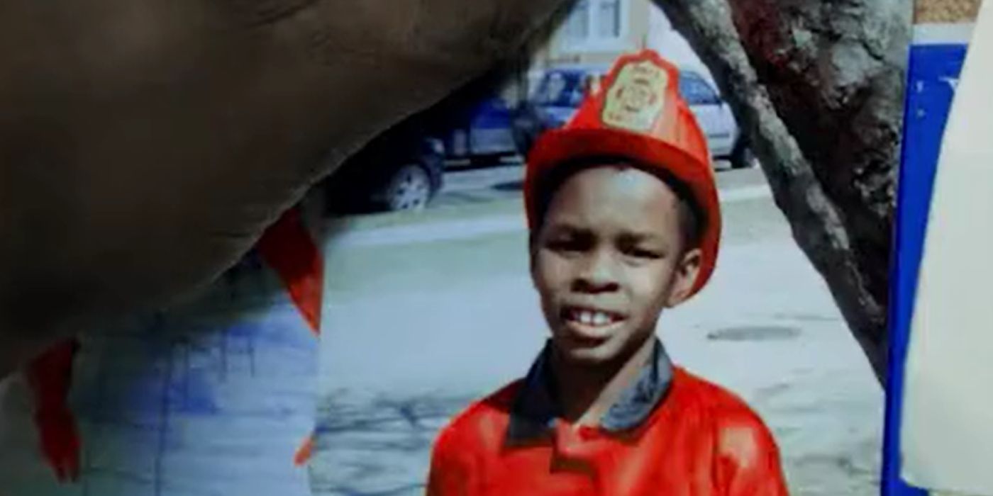 An image of a boy dressed as a firefighter being pined to a wall in the 'Chicago Fire' episode "A Coffin That Small"