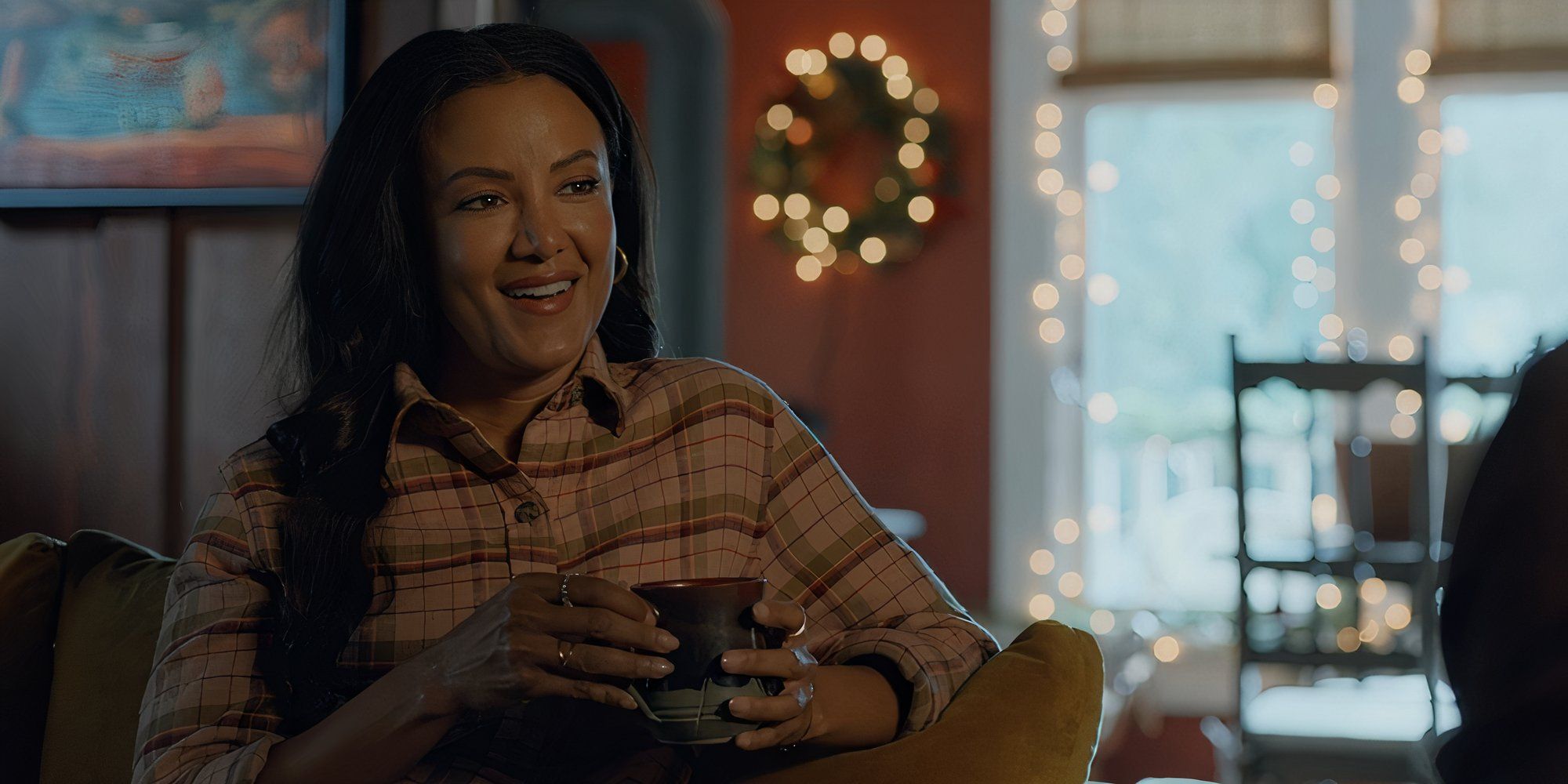 Heather Hemmens as Emily sits with a mug in her hands in Christmas Under the Lights.