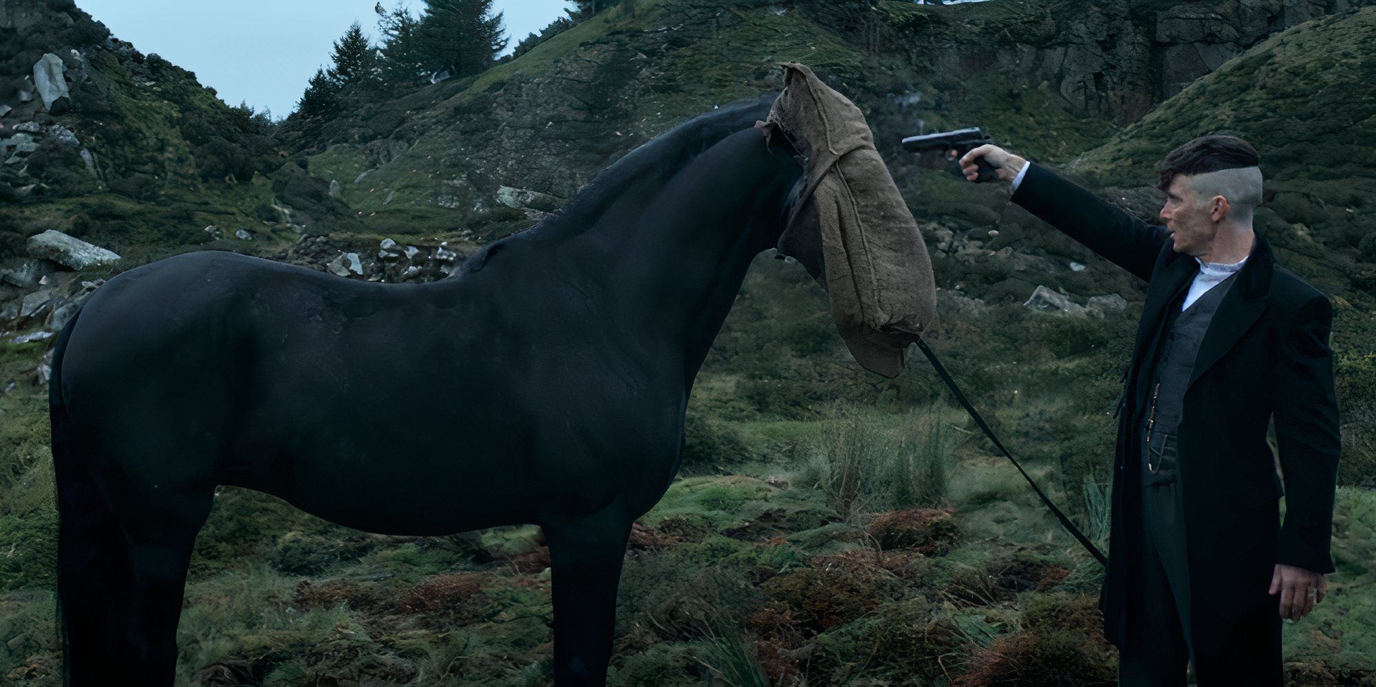 Cillian Murphy as Tommy Shelby pointing a gun at an horse in Peaky Blinders