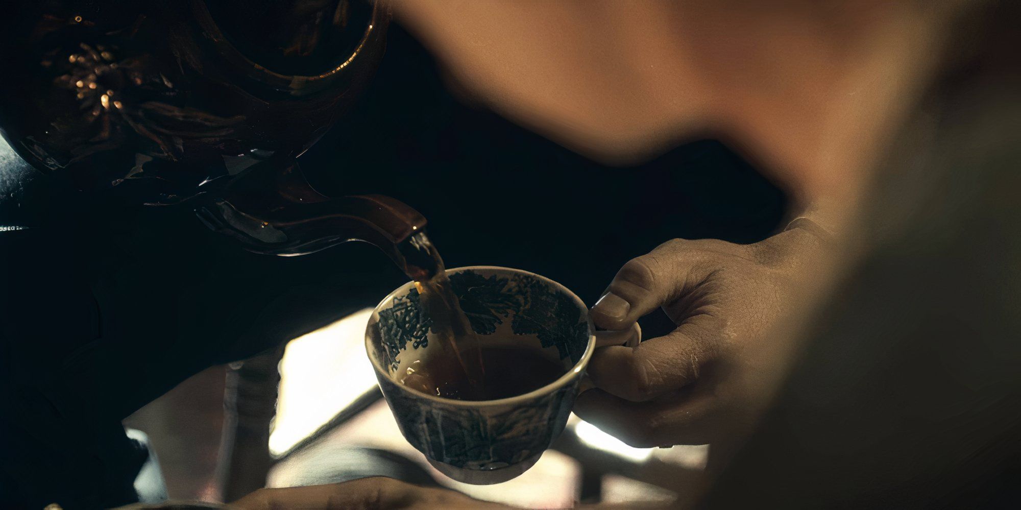 Cillian Murphy as Tommy Shelby pouring himself tea in Peaky Blinders