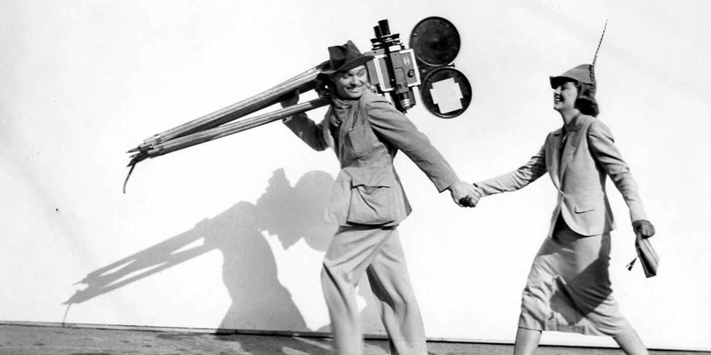 Clark Gable (Chris) carrying his newsreel camera while holding Myrna Loy&rsquo;s (Alma) hand in Too Hot to Handle