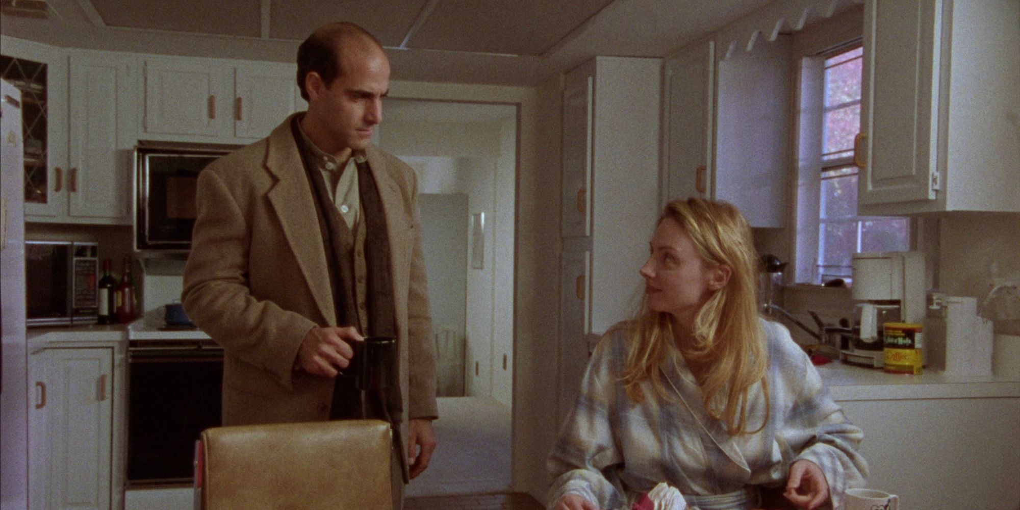 Louis D’Amico (Stanley Tucci) and Eliza D’Amico (Hope Davis) looking at each other in the kitchen in The Daytrippers (1996)