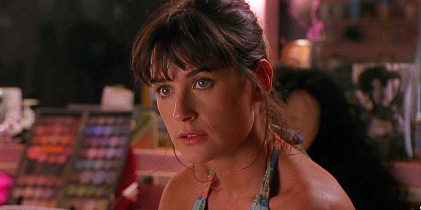 Demi Moore wears her hair up with bangs in a halter top as she looks off-camera in the movie Striptease.