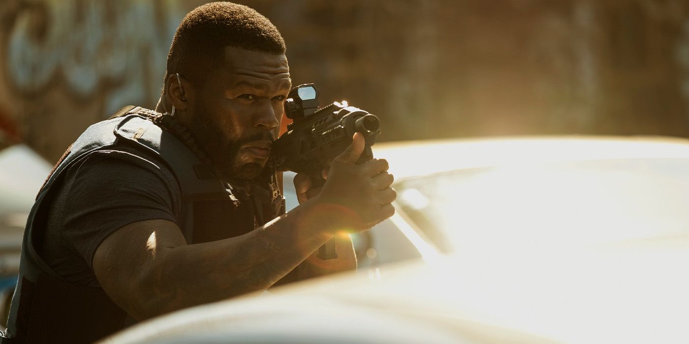 Enson (50 Cent) aiming a gun over a car door in Den of Thieves