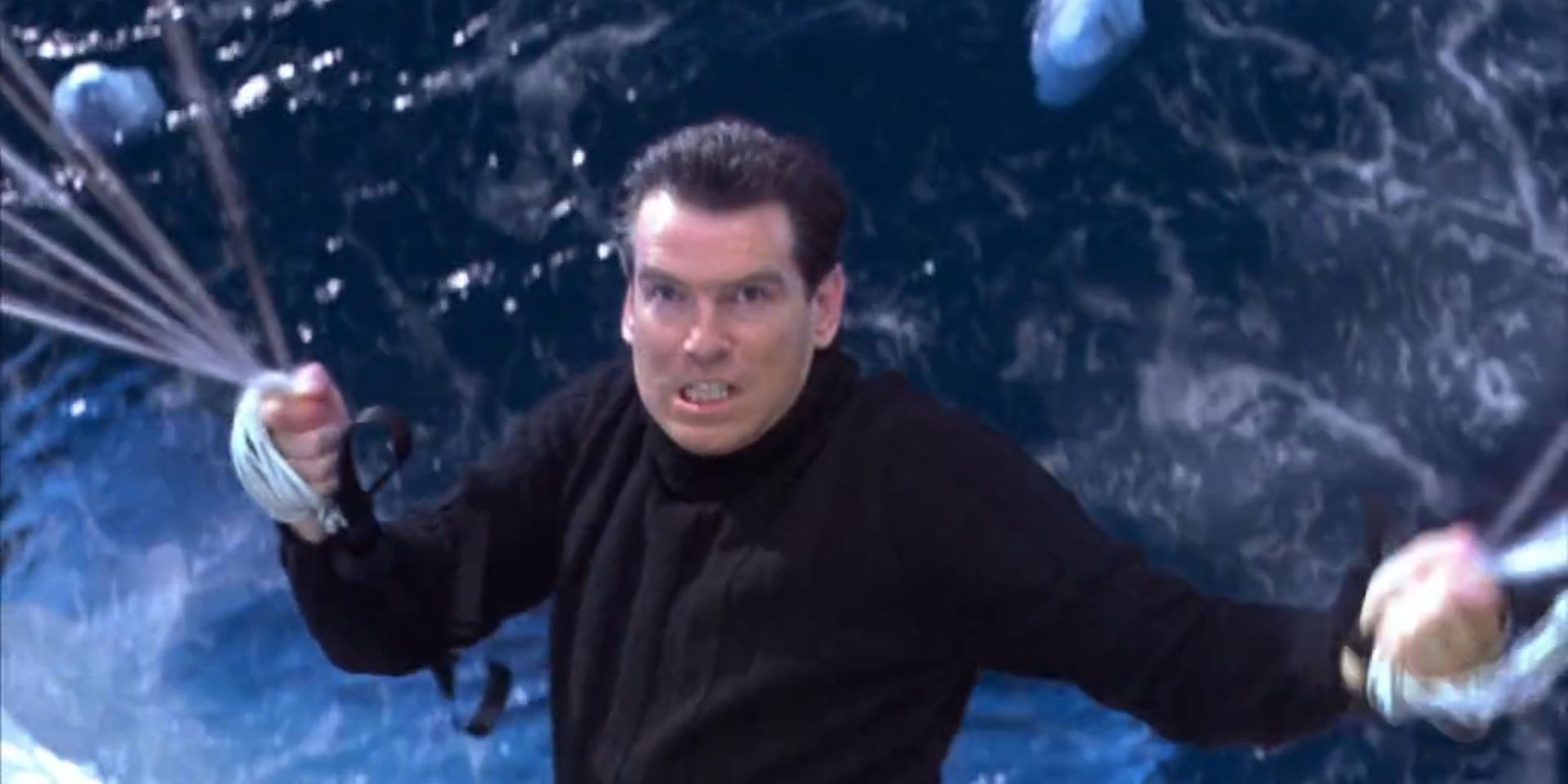 James Bond, played by Pierce Brosnan, holds onto the strings of a parachute while surfing on a tidal wave in &lsquo;Die Another Day&rsquo;.