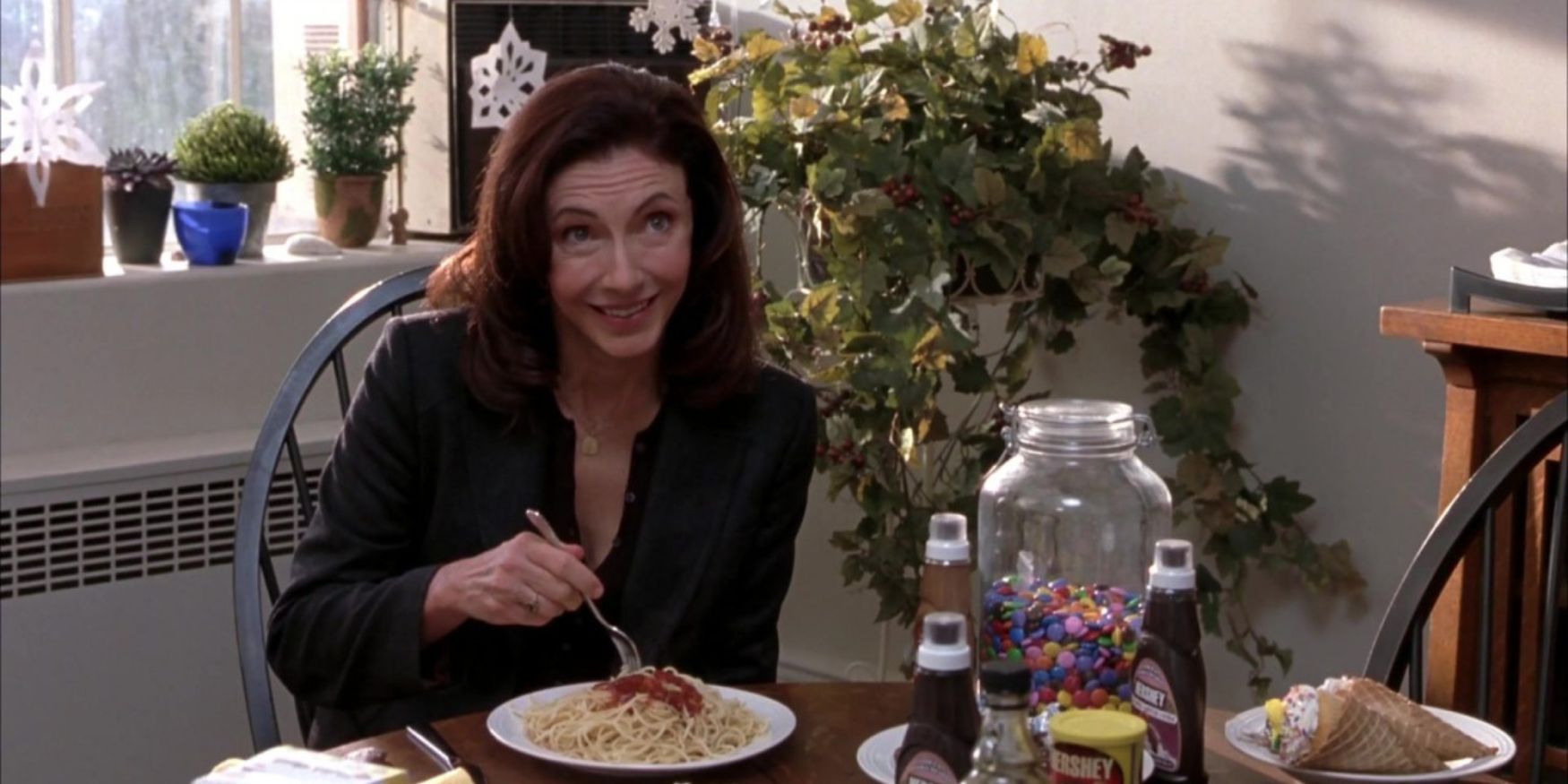 Mary Steeenburgen as Emily Hobbes eating a plate of spaghetti with a bunch of sugar treats on top in Elf.