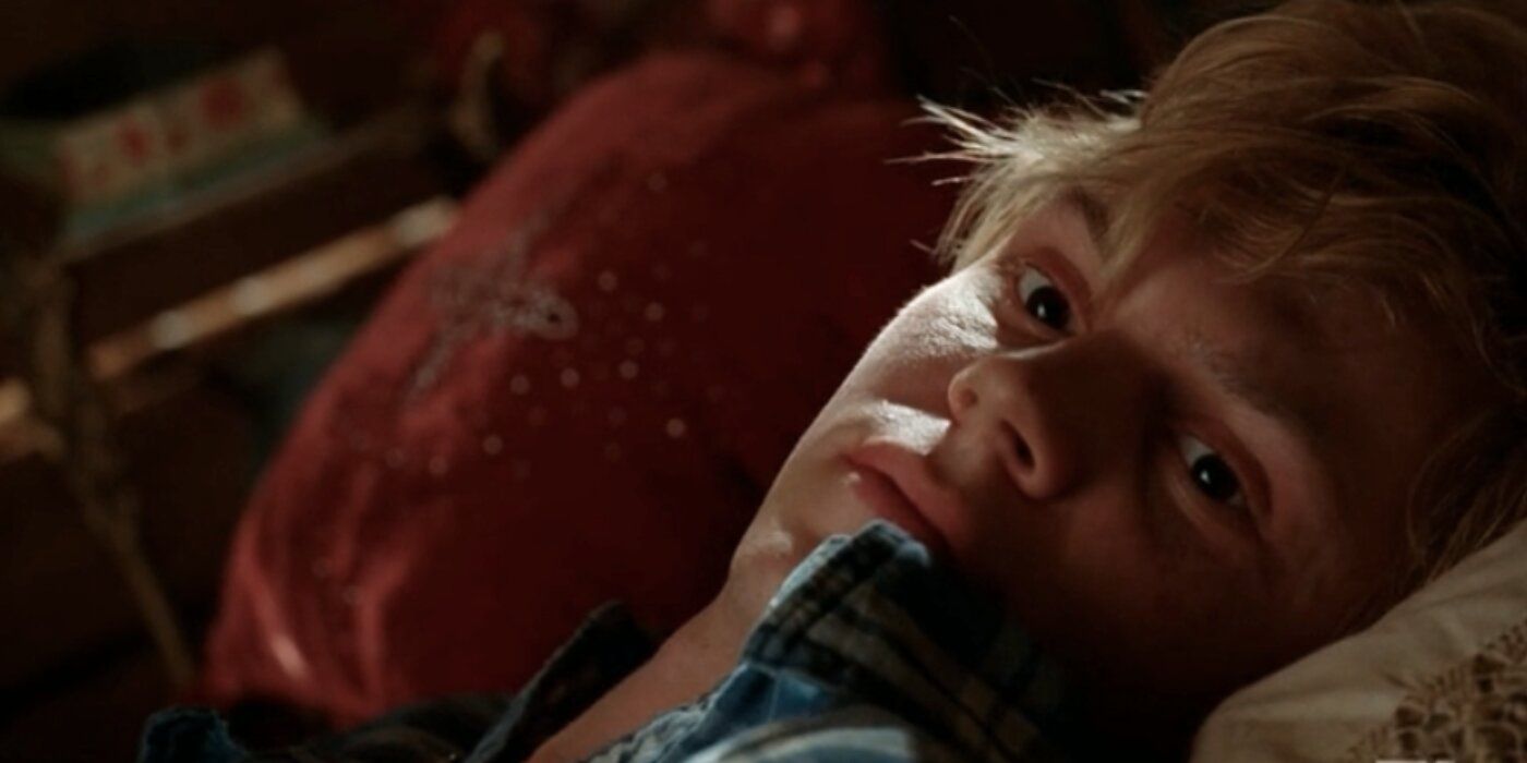 Kyle Spencer lying in a bed in AHS: Coven.