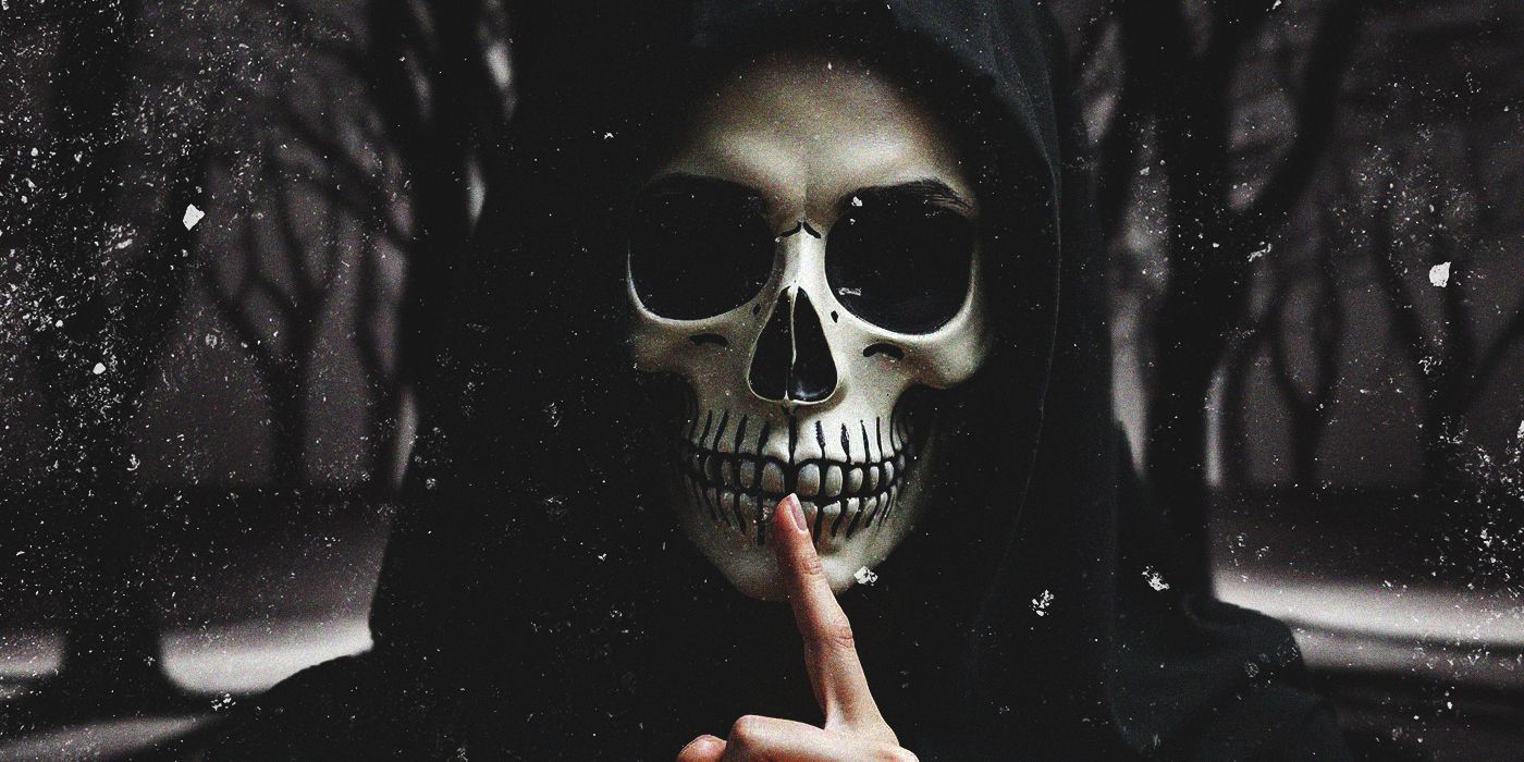 A hooded figure wearing a skeleton mask holds a shushing finger to its mouth in front of a snowy backdrop.