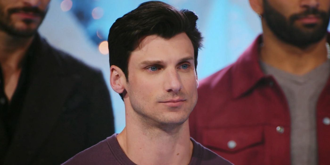 Gage stands with the other contestants and looks tense in Finding Mr. Christmas.