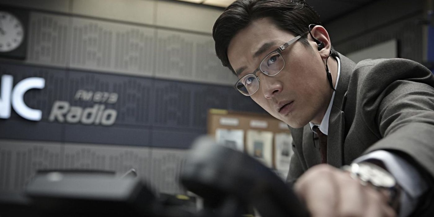 Ha Jung woo as a radio show host, wearing a suit and glasses, raising the phone to answer a call