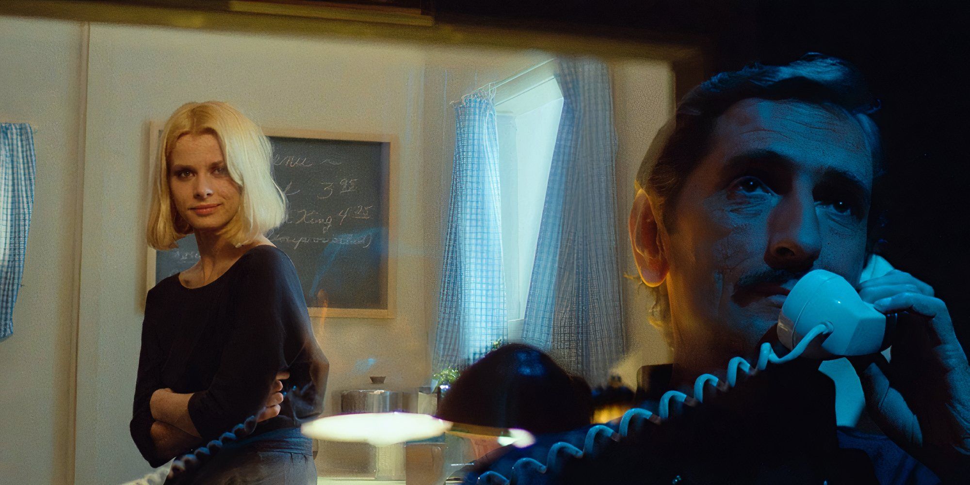 Harry Dean Stanton as Travis Henderson calling someone on the telephone and Natassja Kinski as Jane Henderson standing in the background in Paris, Texas.