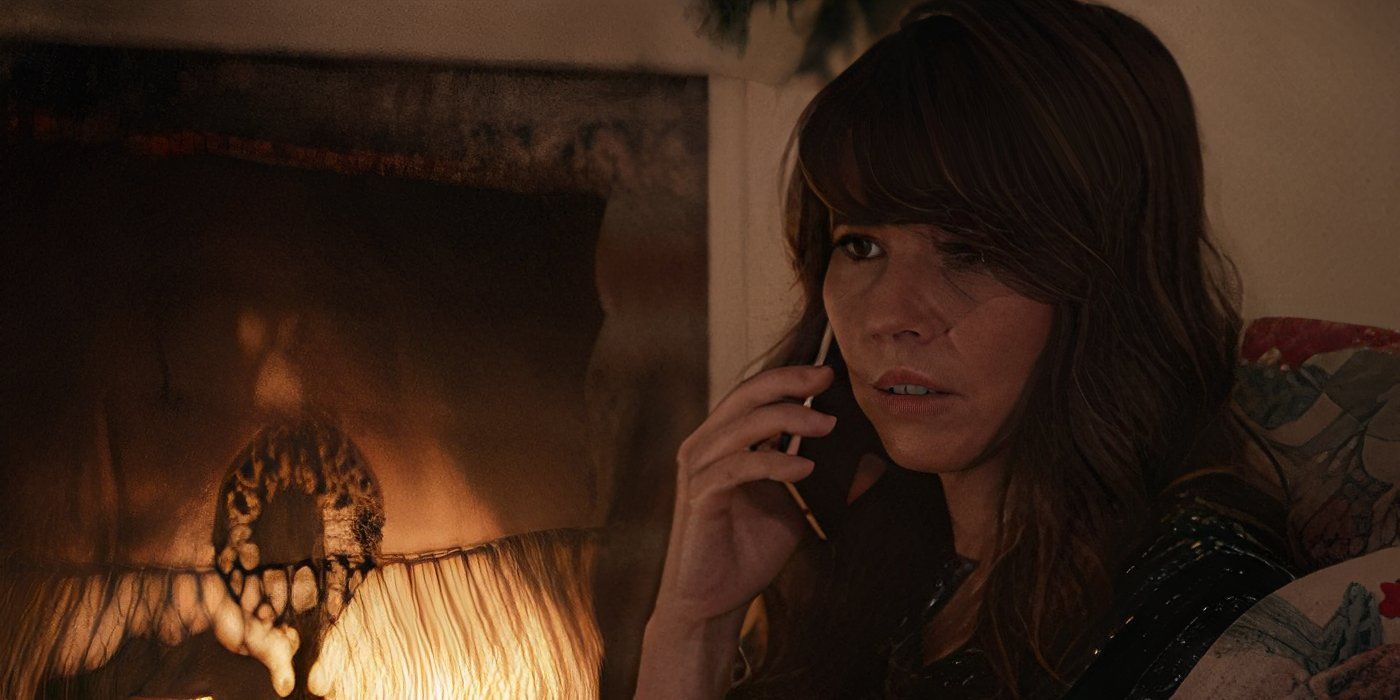 Laura Barton (Linda Cardellini) talks to her husband on the phone by the fireplace in Marvel Studios' 'Hawkeye'.