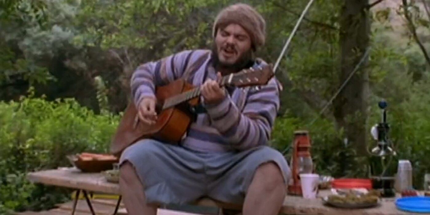 Jack Black as Devlin playing the acoustic guitar while sitting on a picnic table in 'Bongwater'